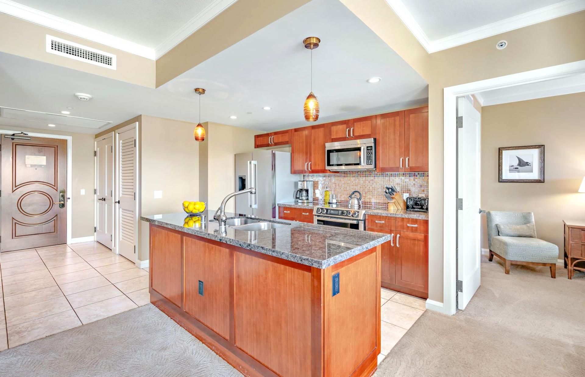 A spacious kitchen with wooden cabinets, a granite countertop, and stainless steel appliances.