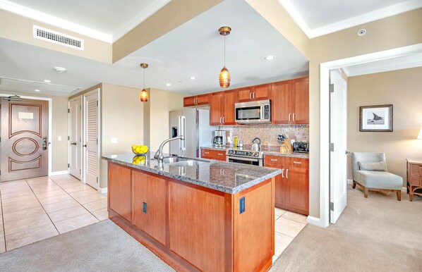 A spacious kitchen with wooden cabinets, a granite countertop, and stainless steel appliances.