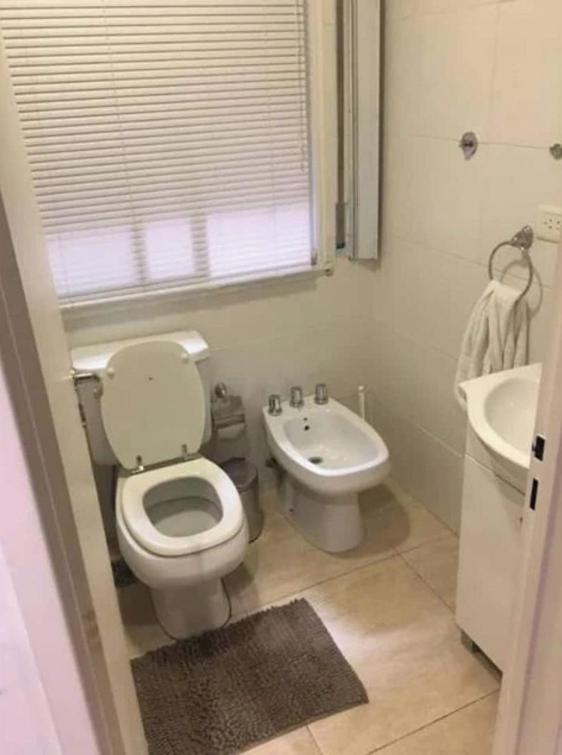 Un baño pequeño con inodoro, bidé y lavamanos.