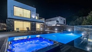 Una casa moderna con piscina y jacuzzi.