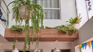Ein Restaurant mit hängenden Pflanzen, einer Kreidetafel als Speisekarte und einer Wand mit Muster.