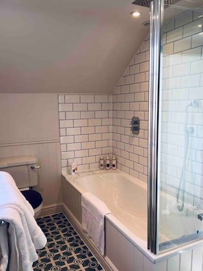 A bathroom with a bathtub, a shower, and a toilet.