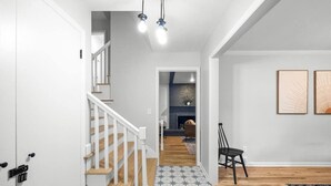 Un intérieur moderne avec un escalier, une cheminée et un coin repas.
