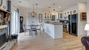 A modern kitchen with white cabinetry, a central island, and stainless steel appliances.