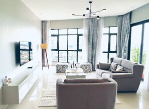 Relax in this stylish living room with a large window, flat-screen TV, and comfortable sofa.