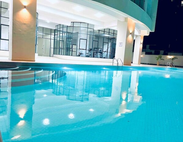 Relax by the pool surrounded by a glass enclosure offering an unobstructed view.