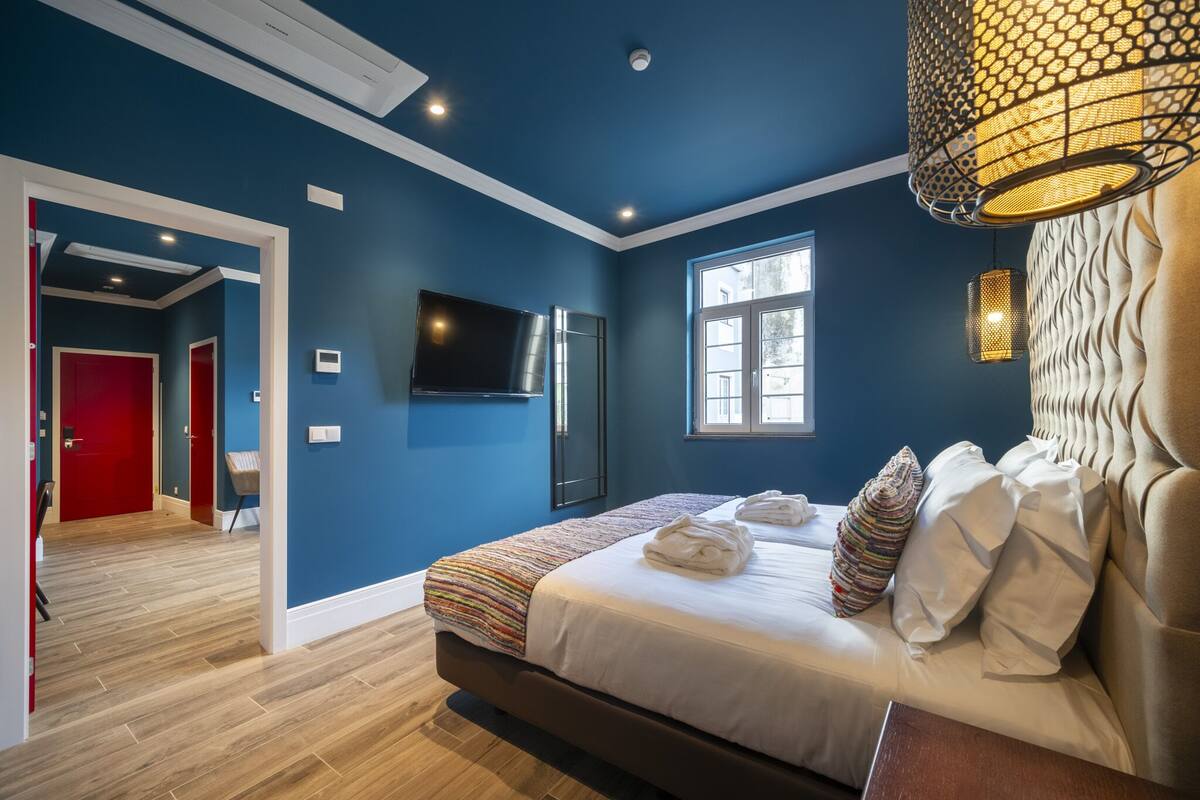 Een moderne slaapkamer met een groot bed, een televisie en een raam.