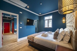 Un dormitorio moderno con una cama grande, un televisor y una ventana.