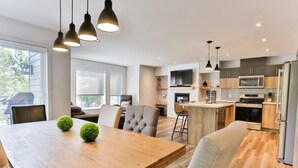 Une cuisine moderne avec des meubles en bois, un îlot central et des luminaires suspendus.
