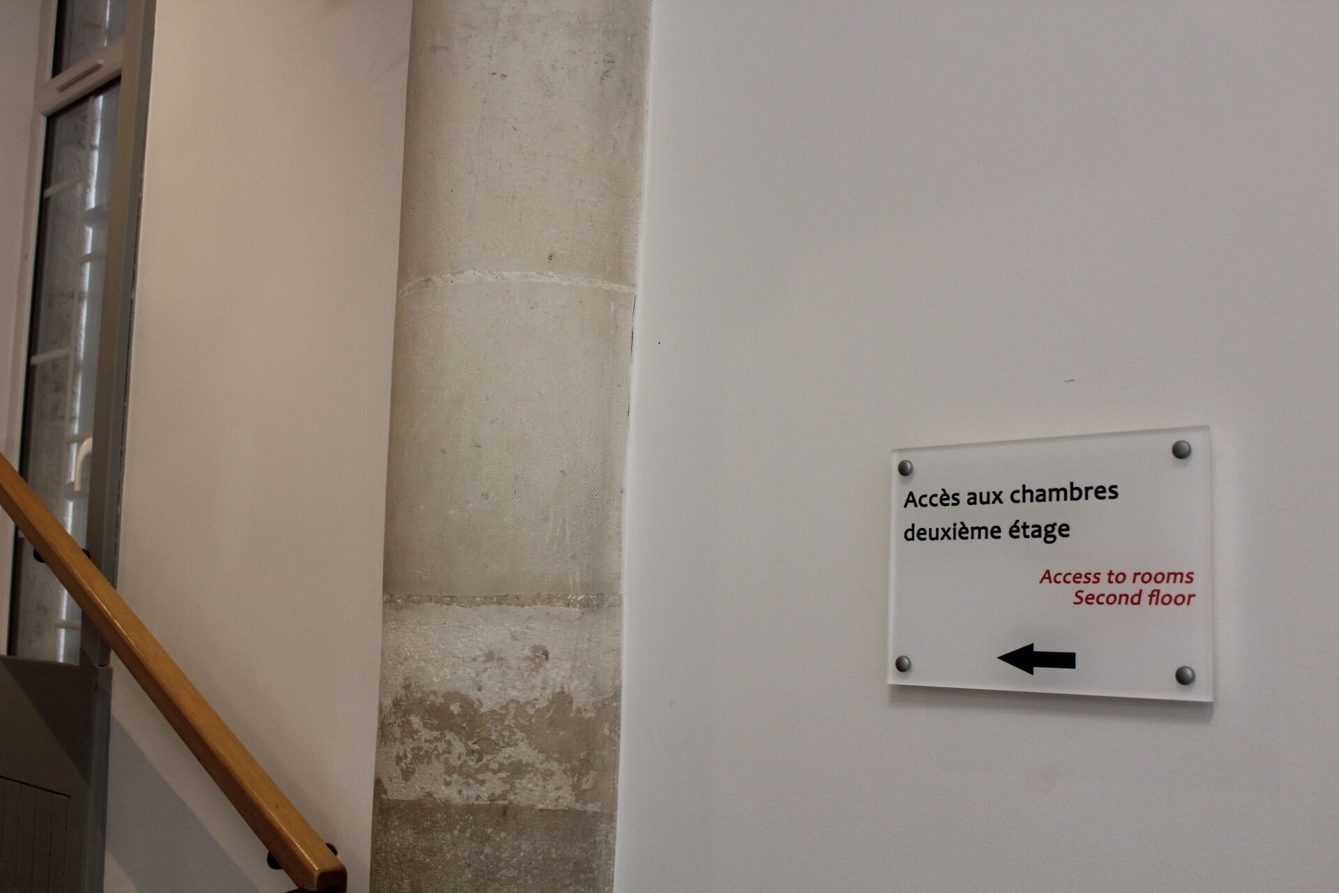 A sign indicating access to rooms on the second floor.