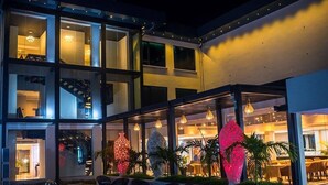Un hotel moderno con area piscina, posti a sedere all'aperto e sculture decorative illuminate.