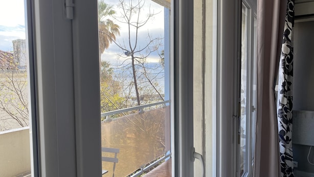 Un balcon donnant sur des arbres et un ciel dégagé.