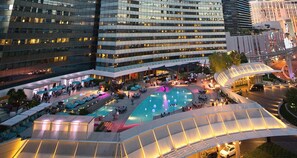 A hotel with multiple swimming pools, outdoor seating areas, and a covered walkway. - Premium Studio Suite at Vdara (Las Vegas)