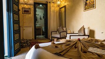 Una habitación de hotel con una cama, una silla, una mesa y un espejo.