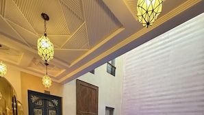 A pool area with a blue pool, potted plants, and a decorative door. - Riad Atrium (Marrakech)