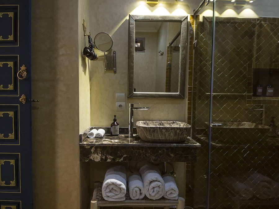A bathroom with a sink, mirror, and towel rack.
