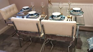 A dining table set with blue floral plates, gold cutlery, and wine glasses. - Home In Birmingham New Street (Birmingham)