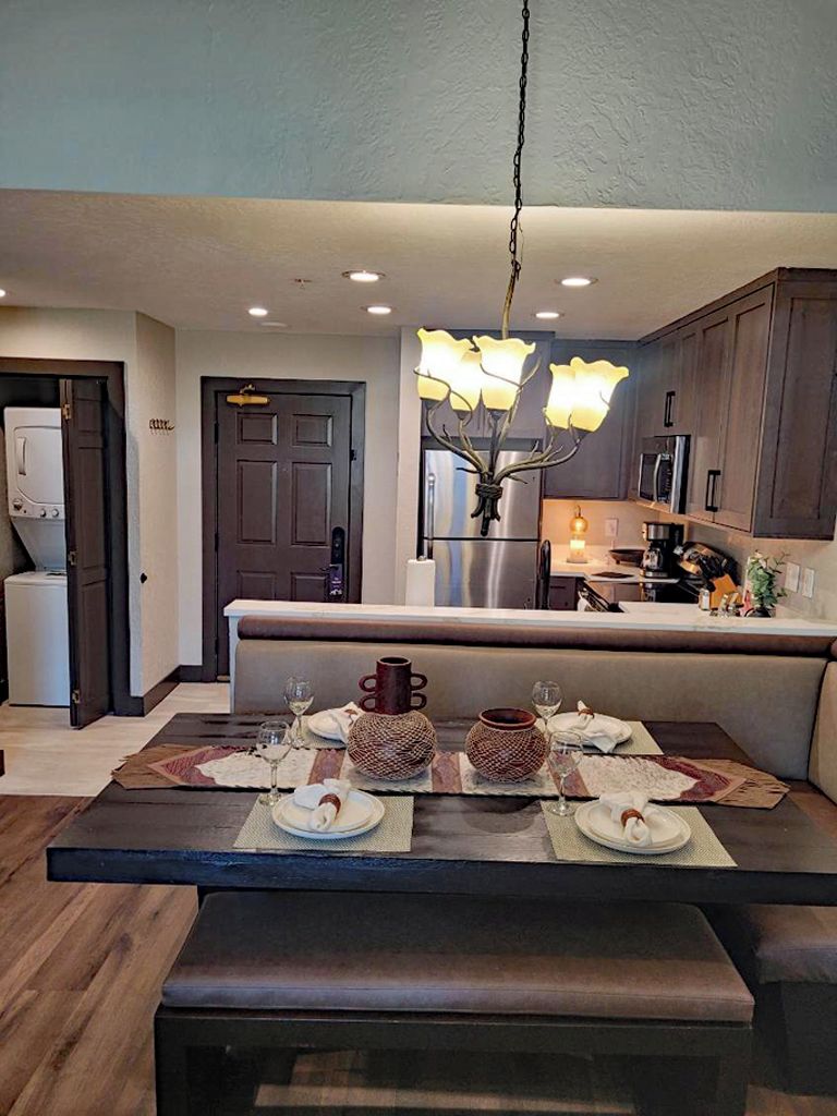 A modern kitchen with dark wooden cabinets, a built-in oven, and a stainless steel refrigerator.