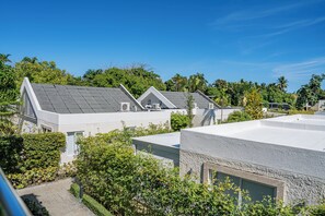 A row of modern buildings with flat roofs, surrounded by lush greenery. - Studio w/ Kitchenette and Balcony Up to 3 Guests with Pool & Beach Access (Puerto Plata)