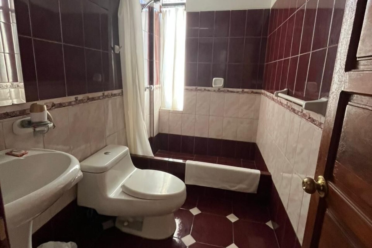 A bathroom with a toilet, sink, and shower area.