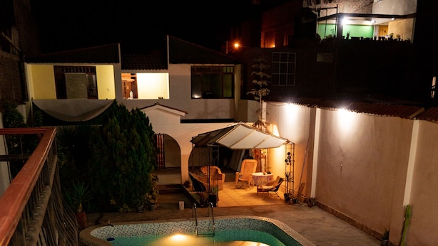 Piscina com deck revestido em azulejo e cerca de madeira.