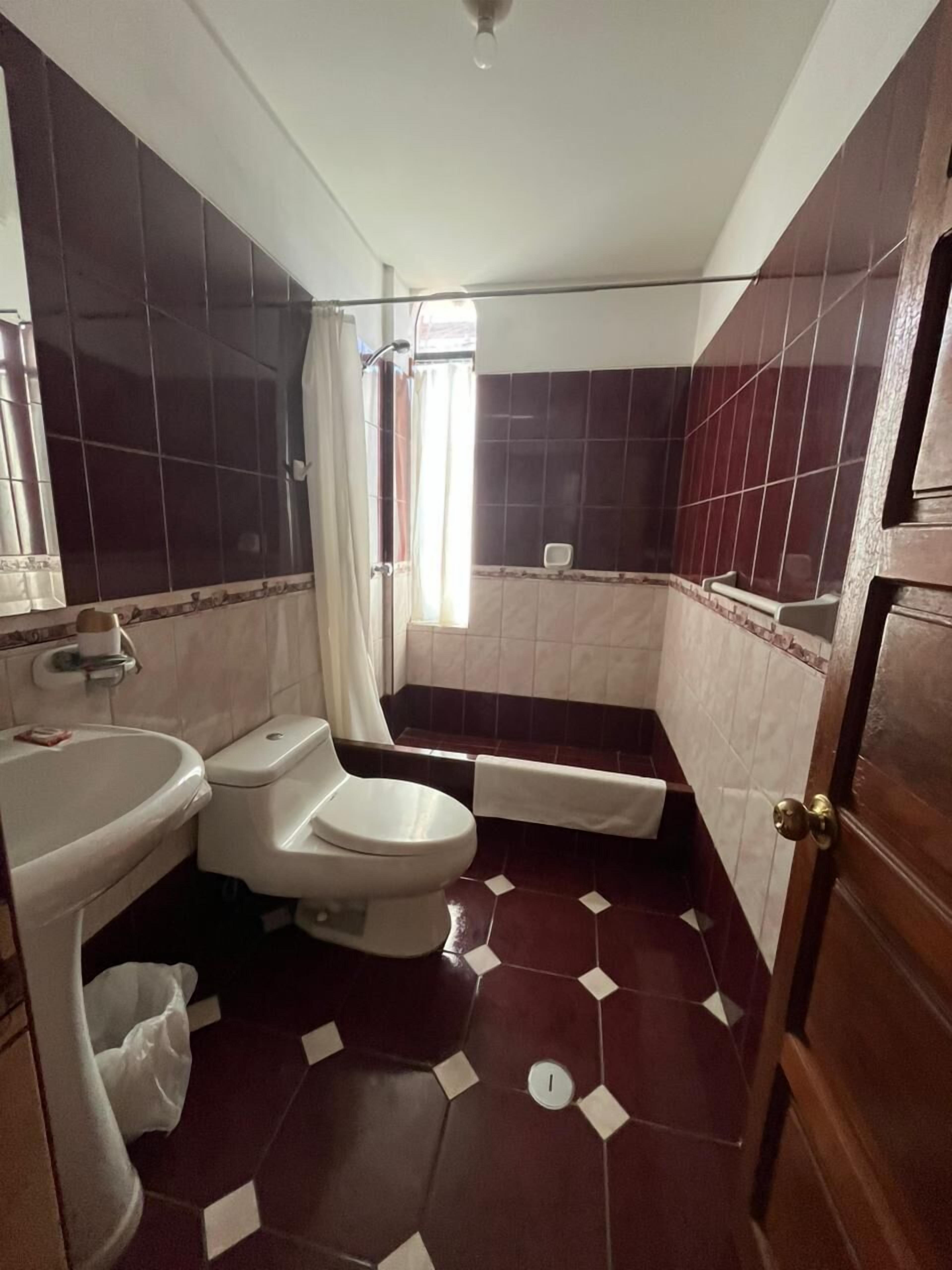 Un baño con inodoro, lavabo y zona de ducha.