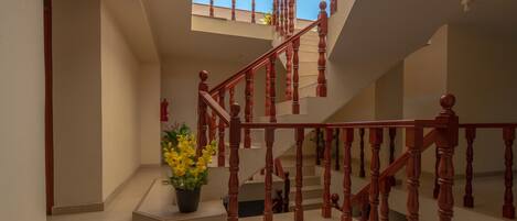 A staircase with wooden balusters and a potted plant at the landing.