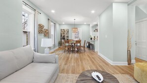 A spacious living room with a sofa, a dining table with chairs, and a coffee table. - Stay in the heart of  Oakley (Cincinnati)