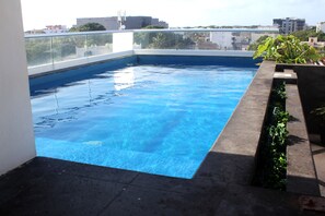 Enjoy a refreshing swim surrounded by lush greenery and city views.