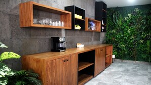 Une cuisine moderne avec des meubles en bois, une machine à café et un mur végétal intégré.