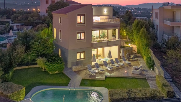 A modern two-story building with a pool and outdoor seating area. - Villa Stefania (Chania)