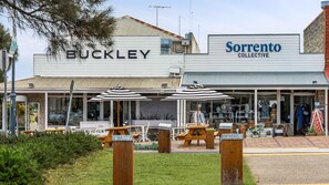 A storefront with 'BUCKLEY' and 'Sorrento Collective' signs, outdoor seating with umbrellas, and a visible entrance. - Great Place to Base Yourself (Sorrento)