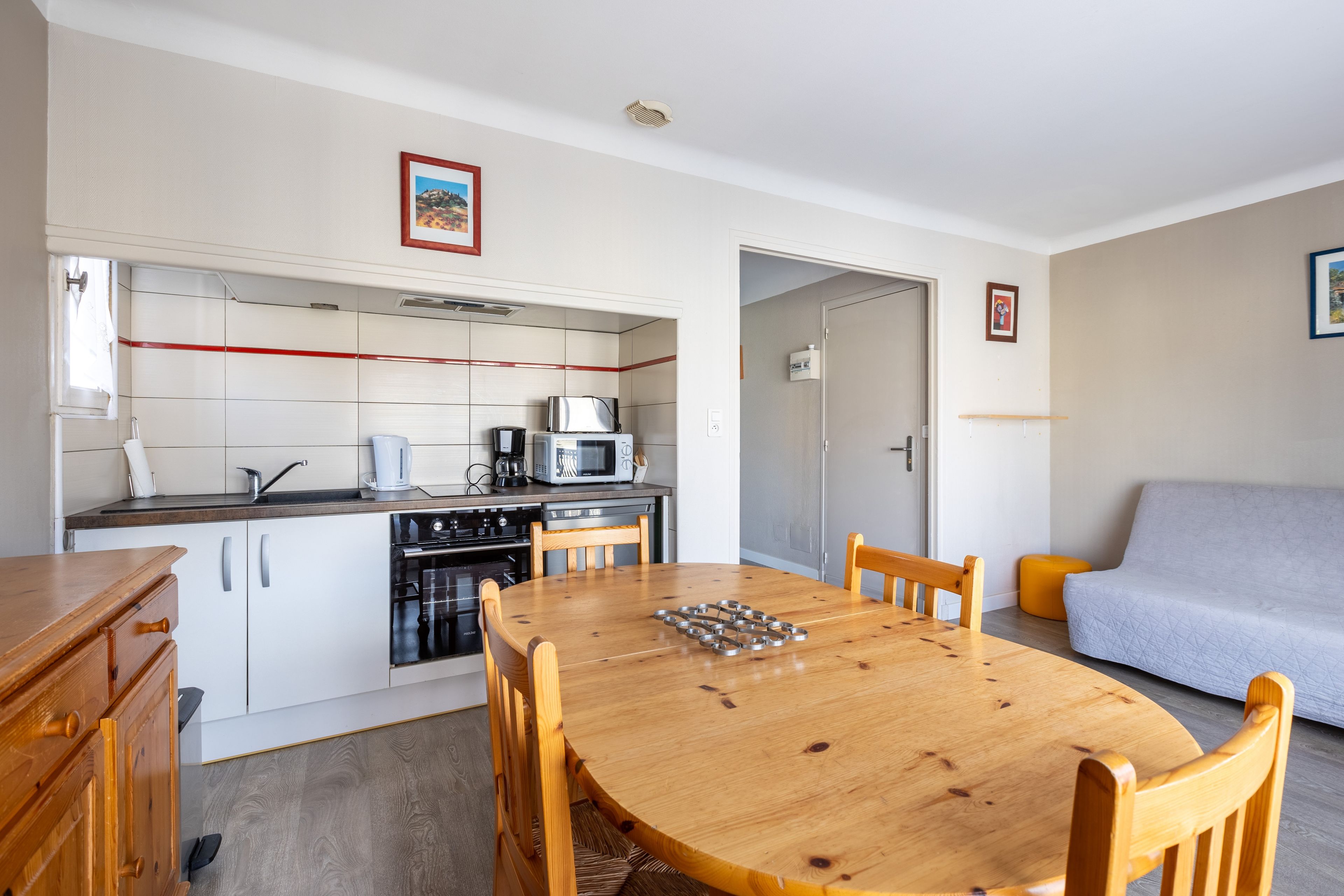 A compact kitchen with white cabinets, a microwave, and a coffee maker.