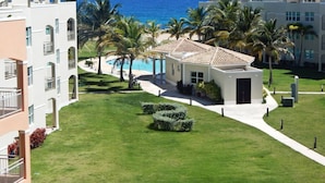 Un resort con piscina, palmeras y vistas al océano.