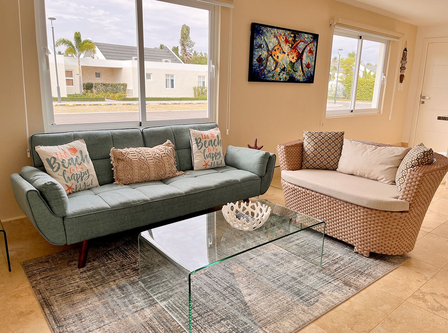A living room with two sofas, a glass coffee table, and a painting on the wall.