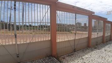 A gated outdoor area with a tiled floor and metal fencing.