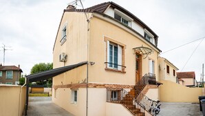 A two-story house with a curved facade, a wooden staircase, and a covered outdoor area. - résidence helios (Villeneuve-Saint-Georges)