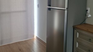 A kitchen with a stainless steel refrigerator, wooden cabinets, and a wooden countertop. - Casa de Alto Padrão Condomínio Privado (Chapada dos Guimarães)