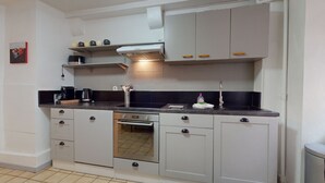 A compact kitchen with a stove, oven, and sink. - Gite de Paul - centre ville Colmar (Colmar)