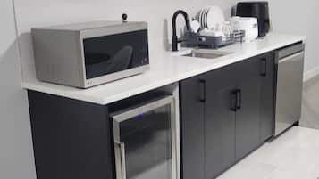 Eine moderne Küche mit Einbau-Mikrowelle, Kaffeemaschine und Geschirrspüler.