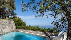 A swimming pool with a stone wall and a view of the sea. - White Villa (Massa Lubrense)