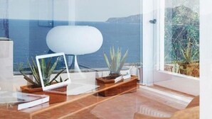 A modern living room with a large glass window overlooking the sea. - White Villa (Massa Lubrense)