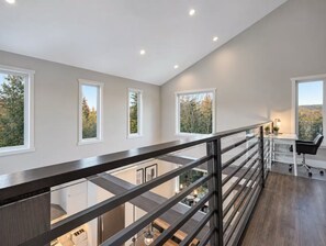 A modern interior with a staircase, multiple windows, and a desk area.