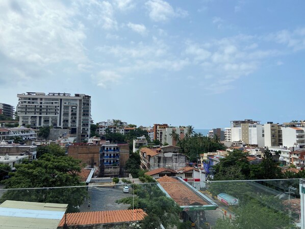 A cityscape with various buildings, including a large multi-story structure and smaller residential buildings.