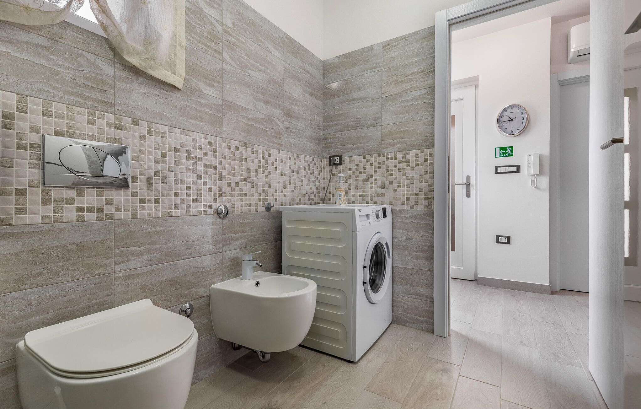Un baño moderno con inodoro, bidé y lavadora.