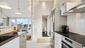 A modern kitchen with white cabinetry, a black countertop, and stainless steel appliances. - 3 bedroom cozy home in Lundby (Lundby)