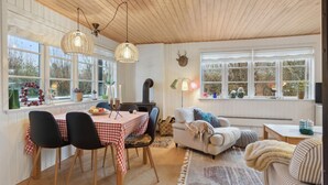 A cozy room with a dining table set for four, a fireplace, and a sofa. - Cozy home in Haderslev with WiFi (Haderslev)