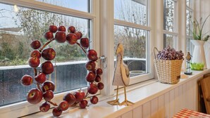 A window sill with a decorative apple arrangement, a bird sculpture, and a basket with flowers. - Cozy home in Haderslev with WiFi (Haderslev)
