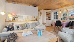 A cozy living room with a sofa, coffee table, and a dining area with a table and chairs. - Cozy home in Haderslev with WiFi (Haderslev)
