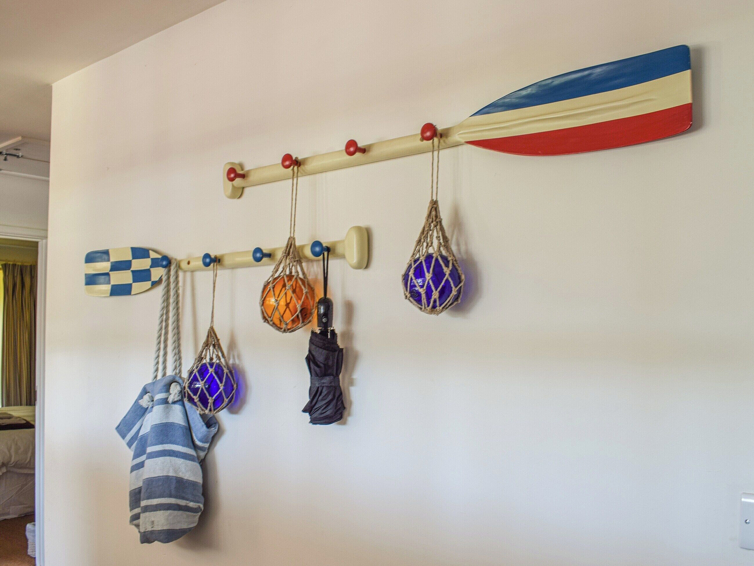 A wall with a horizontal rack holding various items.